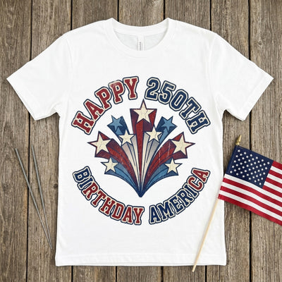 Styled flatlay of Happy 250th Birthday America white tee with sparklers