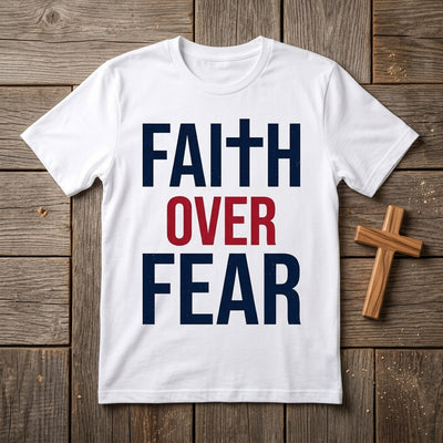 Styled flatlay of Faith Over Fear white tee with wooden cross
