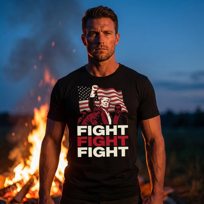 Man wearing Fight Fight Fight Trump black t-shirt by bonfire at dusk