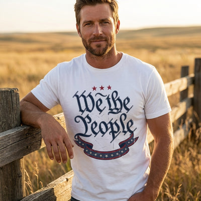 Man wearing We The People white t-shirt at ranch fence