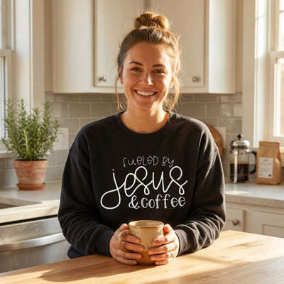 Woman in kitchen wearing Fueled by Jesus and Coffee sweatshirt